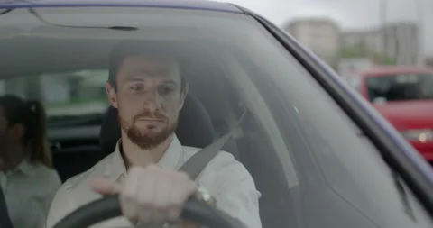 Young taxi driver with a beard is checking time while waiting on a red light. Stock Footage 146523436