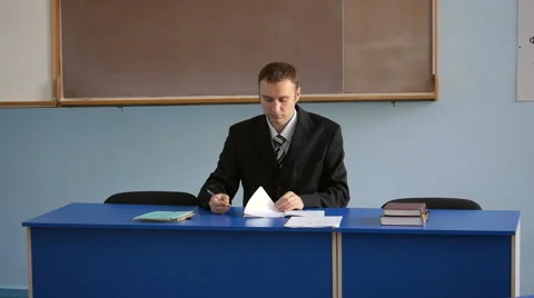 The young teacher checking work in the classroom Stock Footage 64216266