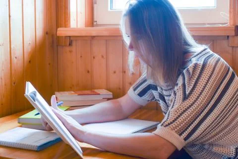 A young teacher checks homework. To write assignment home Stock Photos