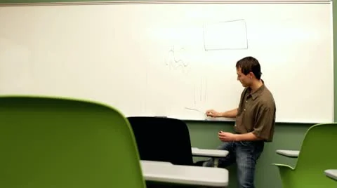 Young teacher drawing on board for empty class Stock-Footage 10700120