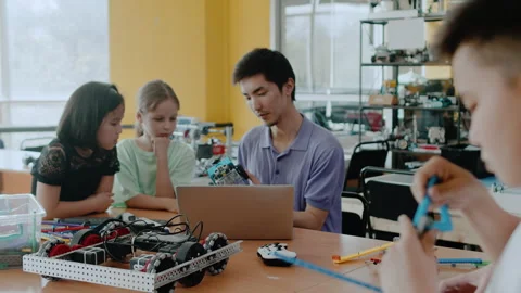 Young teacher explain to the children how the moving module of the robot works 库存影片 242495827