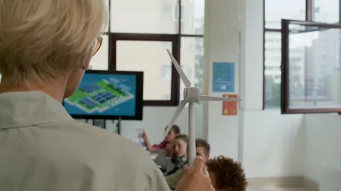 Young Teacher Making Presentation of Windmill Model to Schoolchildren Stock Footage 316481698