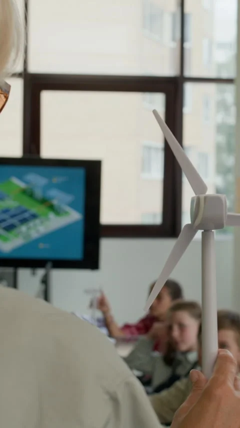 Young Teacher Making Presentation of Windmill Model at Lesson of Ecology Stock Footage 316484494
