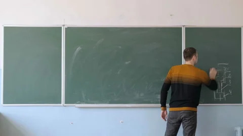 Young Teacher Or Student Erasing Chalkboard In Classroom, Lecture Hall Stock Footage 164900806