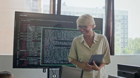 Young Teacher of Programming Laughing while Answering Questions of Schoolkids Stock Footage 316478456