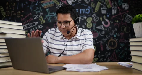 Young teacher sitting in classroom has blackboard on background Video stock 201228619