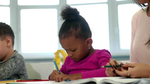 Young teacher working with her pre-school little students at classroom  Stock Footage 94972312
