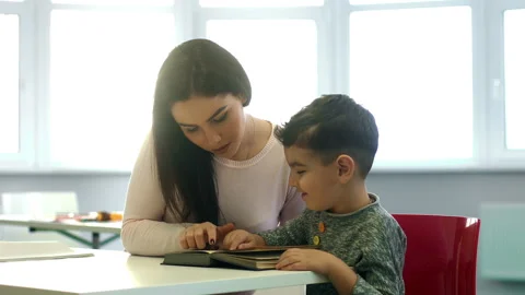 Young teacher working with her pre-school little students at classroom  Stock Footage