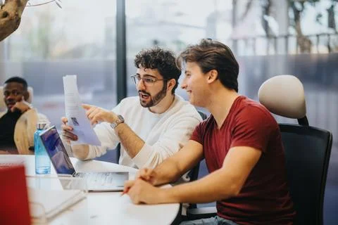 Young team brainstorming, analyzing stats, and solving problems for business Stockfoto's