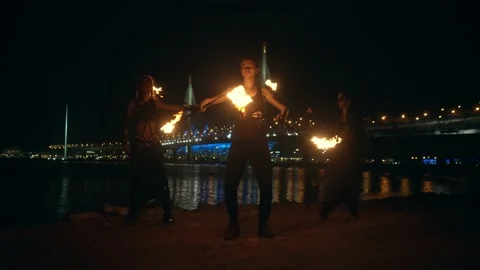 Young team with burning staff doing fire show on concrete background bridge and Stock-Footage 194378194