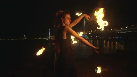 Young team with burning staff doing fire show on concrete background bridge and 库存影片 194379230