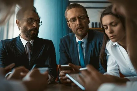 Young team of colleagues app developers testing the bugs of the new app while Stock Photos