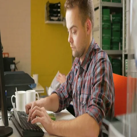 A young team of men working on a project in the office at the computer. Check Video stock 69430798