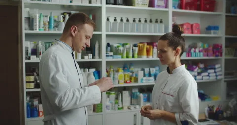 Young team of pharmaceund technician working in chemist shop. Working Stock Footage 144352112