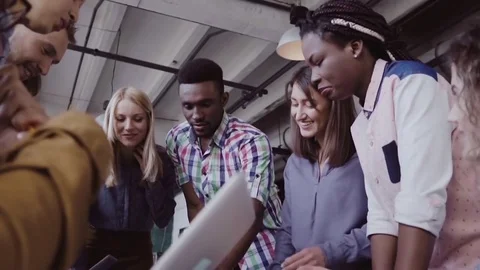 Young team working on new project. Group of mixed race people standing near the Stock-Footage 84453677
