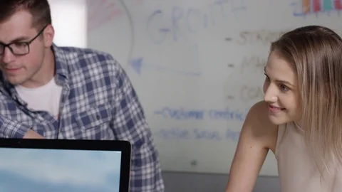 Young tech start up employees laughing in a work meeting Stock Footage 76500132