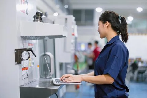 Young technician engineer worker with CNC lathe metal machine in modern ste.. Stock Photos