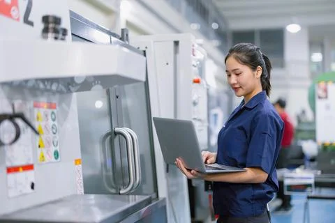 Young technician engineer worker with CNC lathe metal machine in modern ste.. Stock Photos