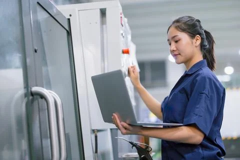 Young technician engineer worker with CNC lathe metal machine in modern ste.. Stock Photos
