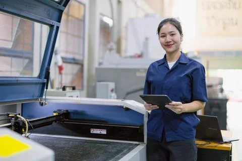 Young technician engineer worker with Metal Laser cutting machine in modern.. Stock Photos