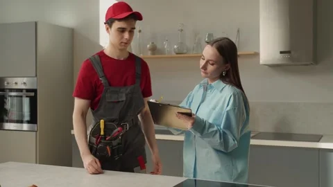 Young Technician in Red Uniform Explaining Service Details to Homeowner in Stock-Footage 274551803