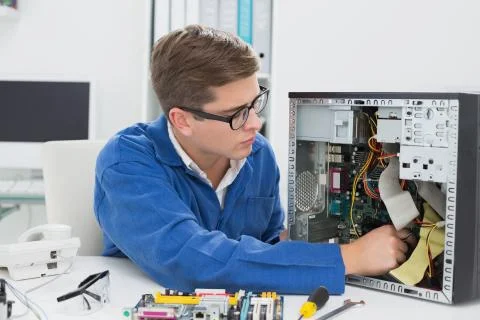 Young technician working on broken computer Stock Photos