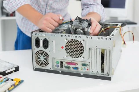 Young technician working on broken computer Stock Photos