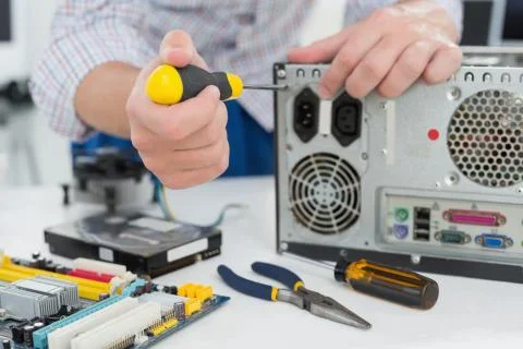 Young technician working on broken computer Stock Photos
