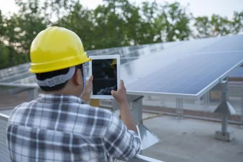 Young technicians use tablet control solar panel power station in the farmlan Stock Photos