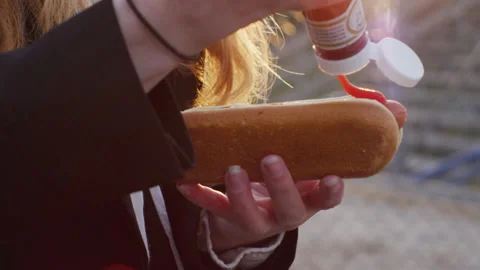 Young teenage girl with orange hair puts Heinz ketchup on delicious tasty Stock Footage 134295077