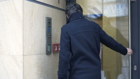 Young teenager input open code on intercome and enter apartment building Stock Footage 87533715