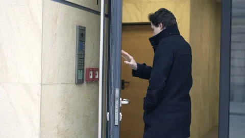 Young teenager input open code on intercome and enter apartment building Stock Footage 87533778