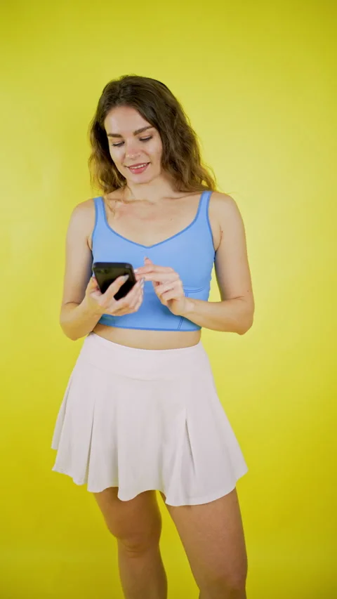 Young tennis player smiling while using smartphone Stock Footage 330484610