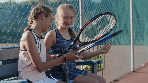 Young tennis players comparing rackets before training Stock Footage 85649536