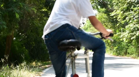 Young Thai boy ride bicycle on the road in the park. 库存影片 68989656