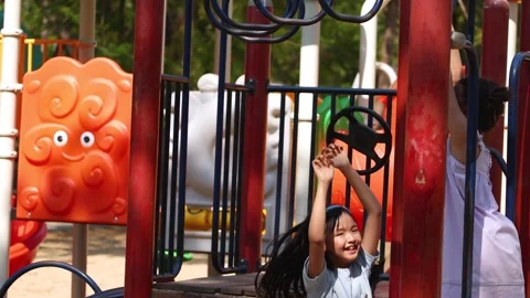 Young Thai Girl Playing on Monkey Bars at Lumpini Park Playground Stock Footage 334165379