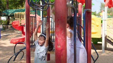 Young Thai Girl Playing on Monkey Bars at Lumpini Park Playground Stock Footage 334165417
