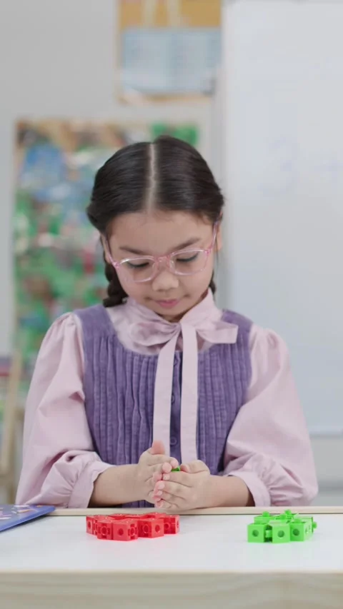 Young Thai Student Using Plastic Blocks for Math Learning in Classroom Stockbeeldmateriaal 334641087