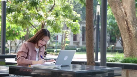 Young Thai University Student Studying with Laptop and Notebook Outdoors Stock Footage 332387852