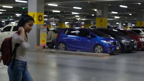 Young Thai Woman with backpack walks in underground parking Stock Footage