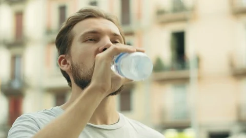 Young Thisty Man Drinks and Enjoys a Bottle of Cold Water Stock Footage 129399542