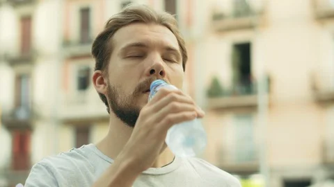 Young Thisty Man Drinks and Enjoys a Bottle of Cold Water Stock Footage 129399600