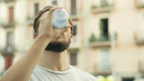 Young Thisty Man Drinks and Enjoys a Bottle of Cold Water Stock Footage 129408756