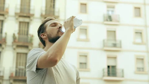 Young Thisty Man Drinks and Enjoys a Bottle of Cold Water Stock Footage 129408913
