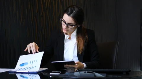 Young thoughtful secretary using a digital tablet at her desk Stock Footage 126595128