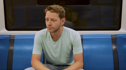 Young thoughtful tired man sit in empty carriage on a subway train. Exhausted Stock Footage 286358352