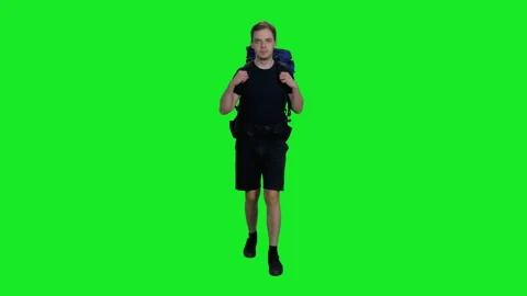 Young tired camper with backpack walking on the road against green screen Stock Footage 159789096