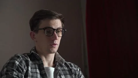 Young tired man closes his laptop after a bad day at work. He takes off his Stock Footage 237017643
