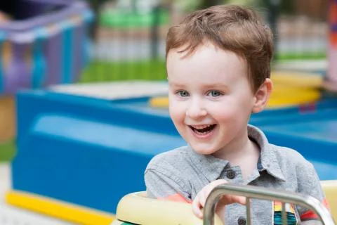 Young toddler boy having fun on boardwalk amusement ride Stock Photos