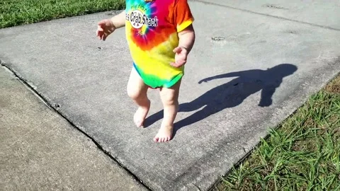 Young toddler trying to run down sidewalk Vídeos de archivo 71163493